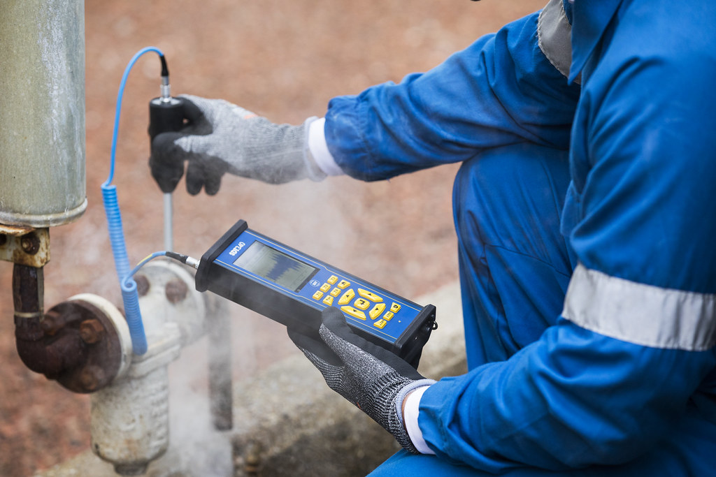 A Technician Using a Portable Device to Collect Vibration Data of an Asset