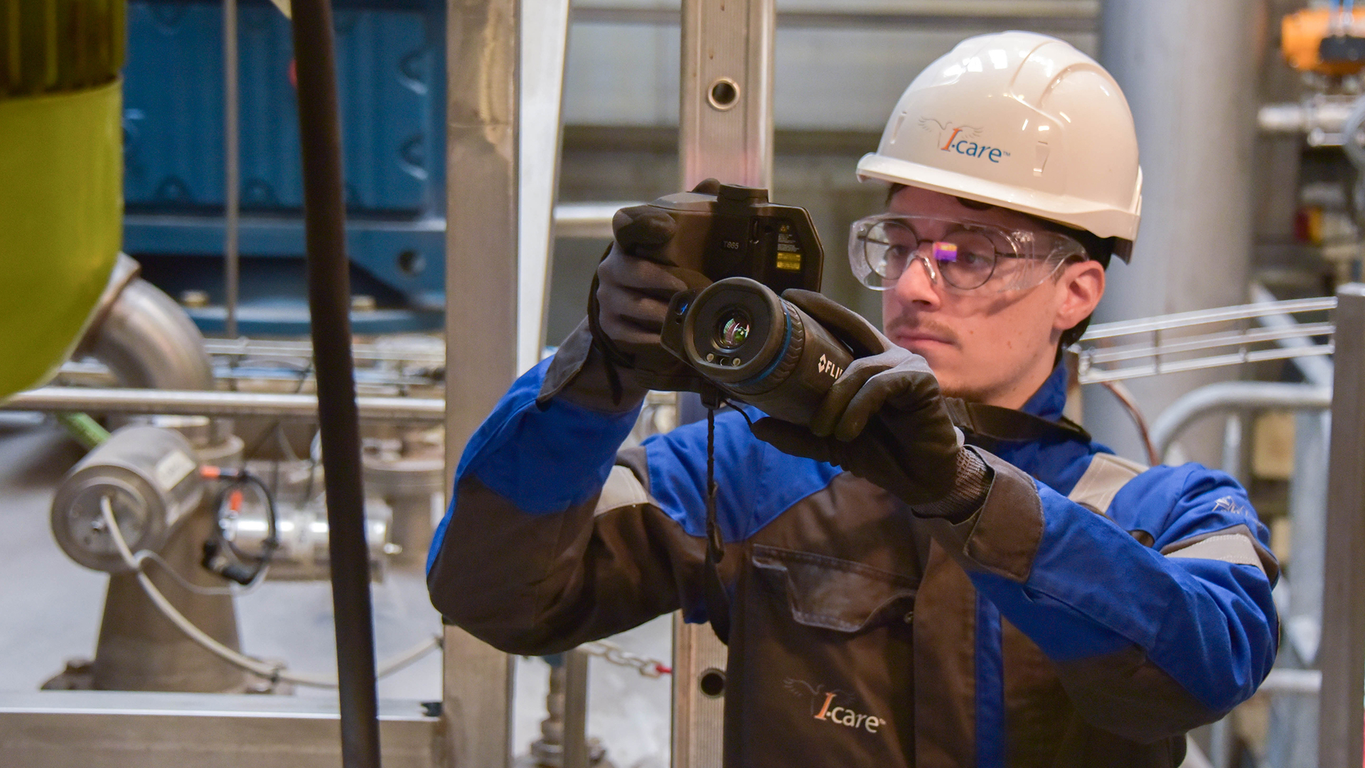 Technician performing infrared thermography inspection on industrial equipment