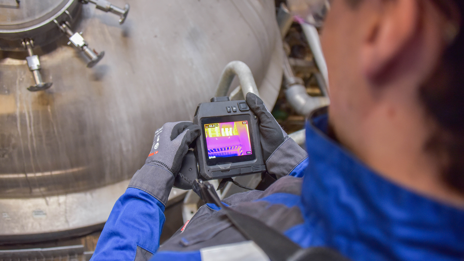 Technician identifying thermal anomaly using infrared thermography camera