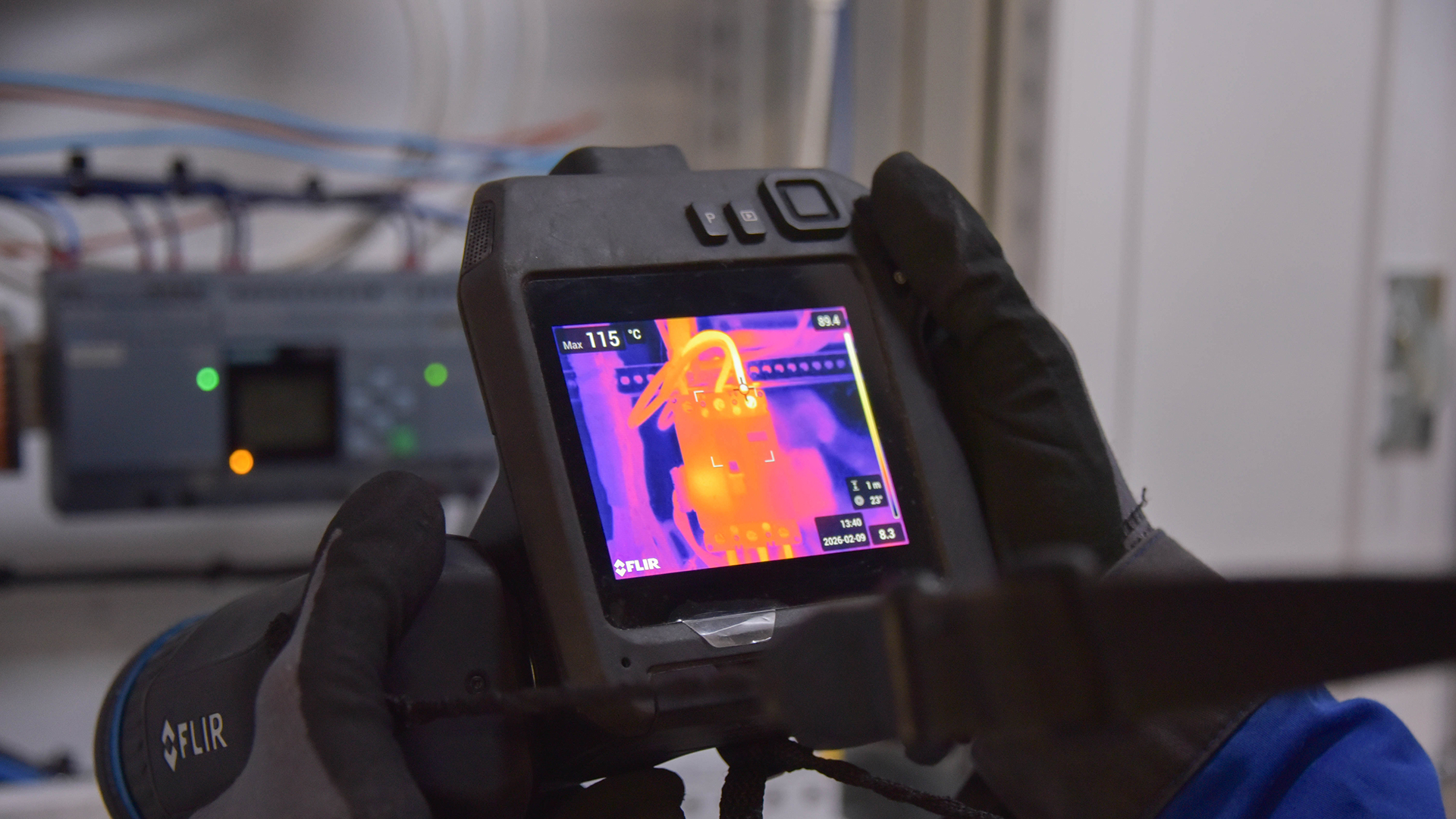 Handheld infrared thermal camera measuring temperature on electrical equipment