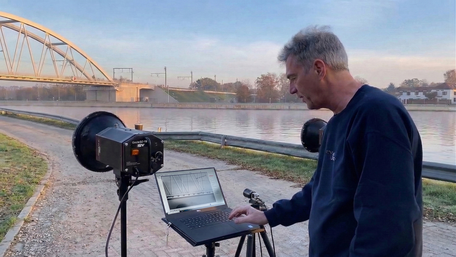 Technician recording structural vibrations with high-speed camera for motion magnification analysis
