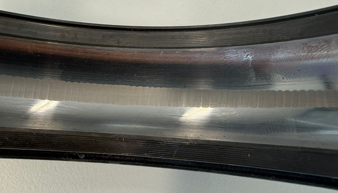 Damaged bearing race surface showing wear patterns and fluting on rolling element bearing